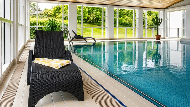 Loungesessel am Beckenrand und Teil des Therapiebeckens der Falkenstein-Klinik